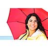 Portrait of beautiful smiling brunette girl wearing yellow raincoat holding red umbrella