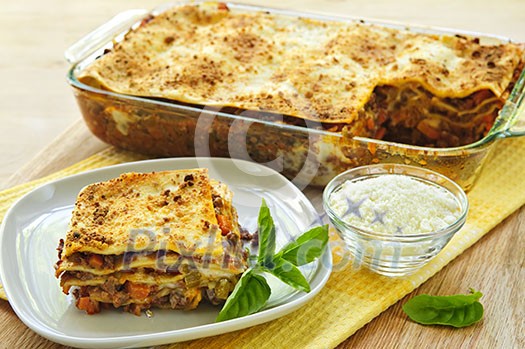 Fresh baked lasagna casserole with a serving cut Fresh baked lasagna casserole with a serving cut