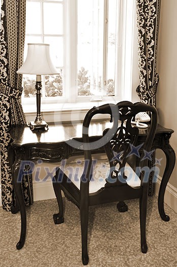 Antique chair and desk near the window in living room