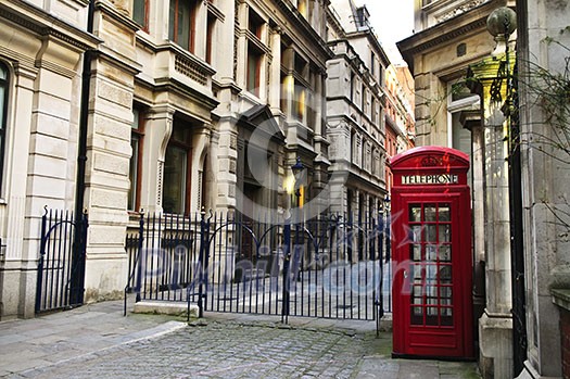Red telephone box near old buildings in London
