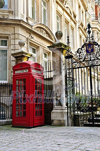 Red telephone box near old buildings in London