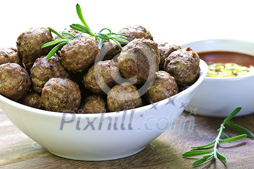 Fresh hot meatball appetizers served in white bowl with dipping sauce Fresh hot meatball appetizers served in white bowl with dipping sauce
