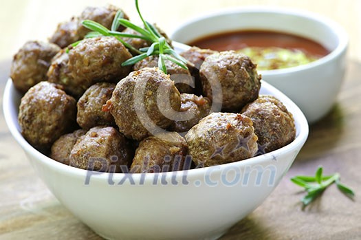 Fresh hot meatball appetizers served in white bowl with dipping sauce Fresh hot meatball appetizers served in white bowl with dipping sauce