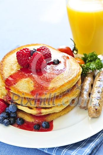 Breakfast of buttermilk pancakes with sausages and fresh berries Breakfast of buttermilk pancakes with sausages and fresh berries