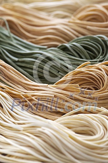 Assorted bundles of colorful raw tagliolini pasta noodles Assorted bundles of colorful raw tagliolini pasta noodles
