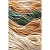 Assorted bundles of colorful raw tagliolini pasta noodles