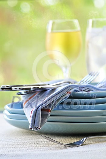 Table setting with stack of plates and cutlery Table setting with stack of plates and cutlery