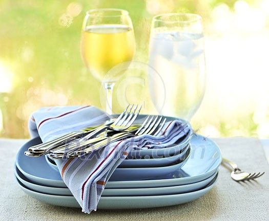 Table setting with stack of plates and cutlery Table setting with stack of plates and cutlery