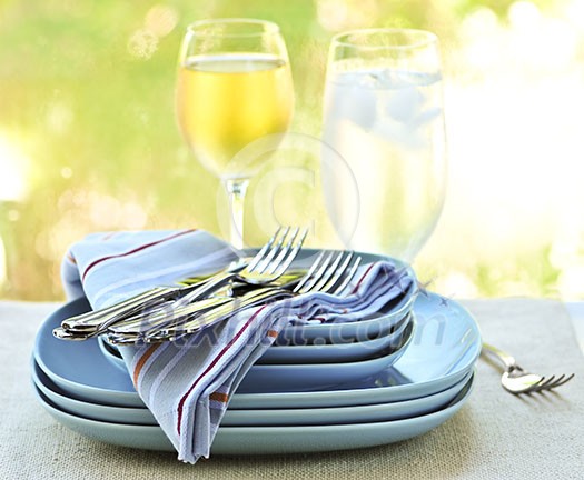 Table setting with stack of plates and cutlery