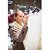 Young woman shopping in a fashion store (color toned image; shallow DOF)