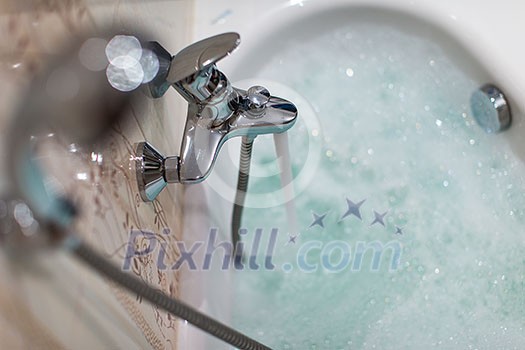 Foamy hot bath in a modern bathroom (shallow DOF; color toned image)