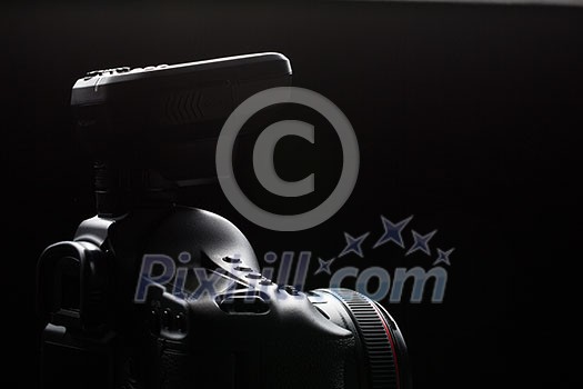 Professional modern DSLR camera low key image - Modern DSLR camera with a very wide aperture lens on Professional modern DSLR camera low key image - Modern DSLR camera with a very wide aperture lens on
