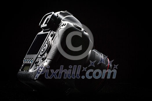 Professional modern DSLR camera low key image - Modern DSLR camera with a very wide aperture lens on Professional modern DSLR camera low key image - Modern DSLR camera with a very wide aperture lens on