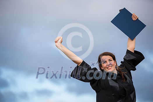 Pretty, young woman celebrating joyfully her graduation - spreading wide her arms, holding her diploma, savouring her success (color toned image; shallow DOF) Pretty, young woman celebrating joyfully her graduation - spreading wide her arms, holding her diploma, savouring her success (color toned image; shallow DOF)
