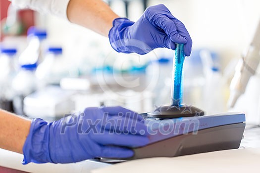 Hands of a female researcher doing research in a lab (shallow DOF; color toned image)