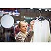 Young woman shopping in a fashion store (color toned image; shallow DOF)