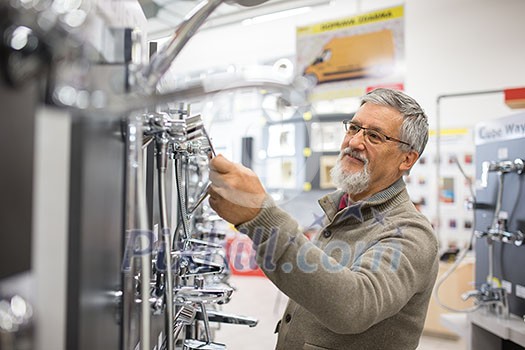 Senior man choosing a bathroom/kitchen tap in a home furnishings retail store