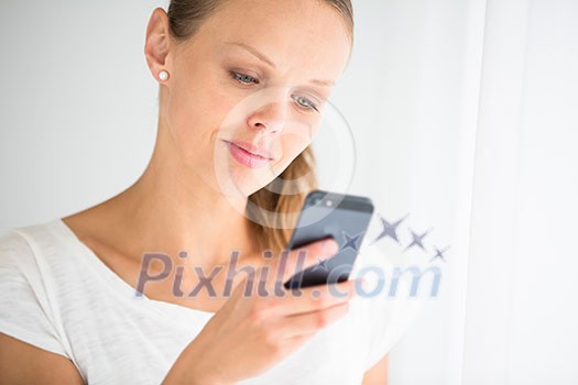 Pretty, young woman calling on her call phone, pensive, concentrating, wearing bright clothes inside a modern, fresh interior (color toned image; shallow DOF)