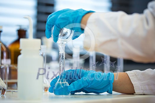 Hands of a female researcher doing research in a lab (shallow DOF; color toned image)