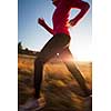 Young woman running outdoors on a lovely sunny winter/fall day (motion blurred image)