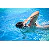 Young man swimming the front crawl in a pool