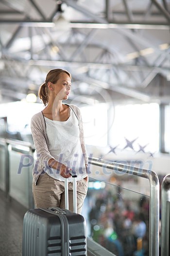 Young female passenger at the airport, about to check-in Young female passenger at the airport, about to check-in