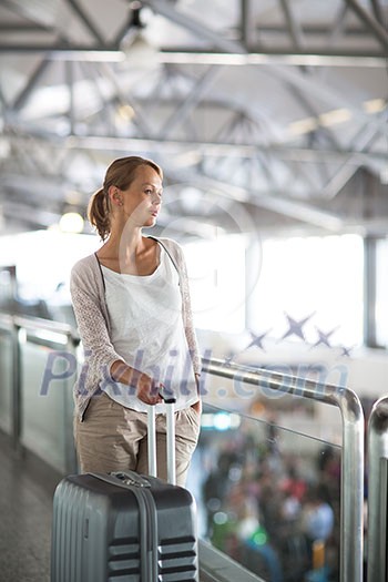 Young female passenger at the airport, about to check-in