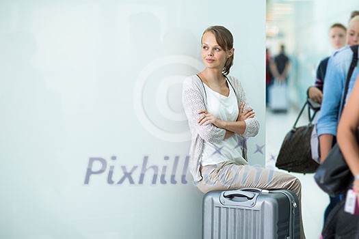 Young female passenger at the airport, about to check-in