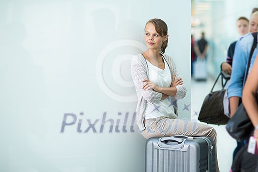 Young female passenger at the airport, about to check-in Young female passenger at the airport, about to check-in