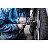 mechanic changing a wheel of a modern car (color toned image)