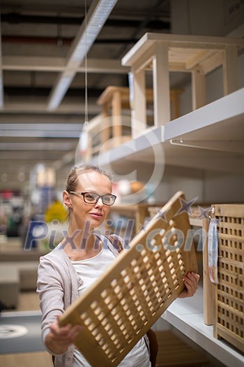 Pretty, young woman choosing the right furniture for her apartment in a modern home furnishings store (color toned image; shallow DOF) Pretty, young woman choosing the right furniture for her apartment in a modern home furnishings store (color toned image; shallow DOF)
