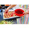 Young woman cooking in her modern kitchen (shallow DOF; color toned image)