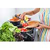 Young woman cooking in her modern kitchen (shallow DOF; color toned image)