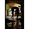 silhouette of couple with umbrella running from rain