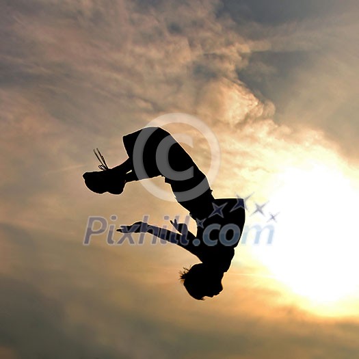 silhouette of jumping man against sky and clouds