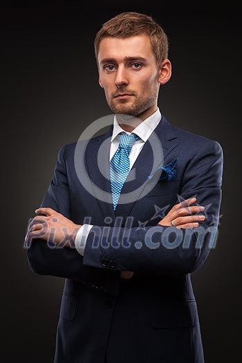 portrait of handsome businessman on black