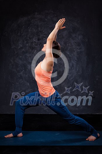 Beautiful sporty fit yogini woman practices yoga asana Virabhadrasana 1 - warrior pose 1 Beautiful sporty fit yogini woman practices yoga asana Virabhadrasana 1 - warrior pose 1