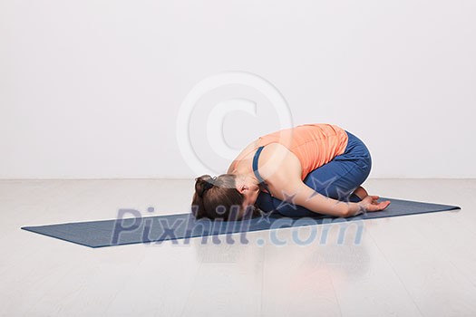 Beautiful sporty fit yogini woman practices yoga asana balasana (child's pose) - resting pose or counter asana for many asanas in studio Beautiful sporty fit yogini woman practices yoga asana balasana (child's pose) - resting pose or counter asana for many asanas in studio