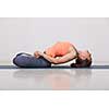 Beautiful sporty fit yogini woman practices yoga asana Matsyasana - fish pose in studio