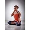 Beautiful sporty fit yogini woman practices pranayama breath control exercise in yoga asana Padmasana - lotus pose with Vishnu mudra in studio