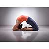 Beautiful sporty fit yogini woman practices yoga asana Kapotasana - pigeon pose intense backbend in studio