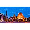 Panorama of Riga Town Hall Square, House of the Blackheads, St. Roland Statue and St. Peter's Church illuminated in the twilight, Riga, Latvia