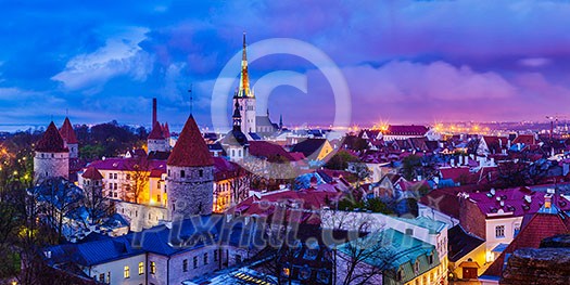 Panorama of aerial view of Tallinn Medieval Old Town with St. Olaf's Church and Tallinn City Wall illuminated in twilight, Estonia Panorama of aerial view of Tallinn Medieval Old Town with St. Olaf's Church and Tallinn City Wall illuminated in twilight, Estonia