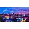 Panorama of aerial view of Tallinn Medieval Old Town with St. Olaf's Church and Tallinn City Wall illuminated in twilight, Estonia