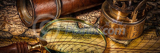 Travel geography navigation concept background - letterbox panorama of old vintage retro compass with sundial, spyglass and magnifying glass on ancient world map