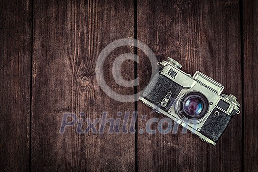 Photography concept background - old retro vintage camera on grunge wooden texture Photography concept background - old retro vintage camera on grunge wooden texture