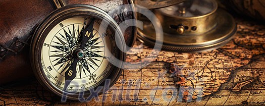 Travel geography navigation concept background - letterbox panorama of old vintage retro compass with sundial, spyglass and rope on ancient world map