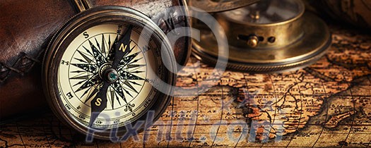 Travel geography navigation concept background - letterbox panorama of old vintage retro compass with sundial, spyglass and rope on ancient world map Travel geography navigation concept background - letterbox panorama of old vintage retro compass with sundial, spyglass and rope on ancient world map