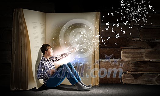 Teenager boy wearing jeans and shirt and reading book Teenager boy wearing jeans and shirt and reading book