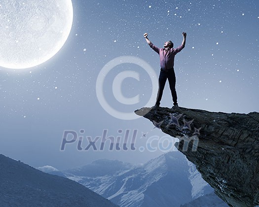 Young screaming man at night with big full moon at background